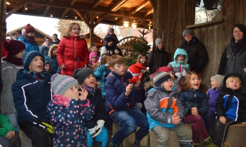 Glückliche Kinder beim Kasperletheater auf dem Weihnachtsmarkt der FloraFarm